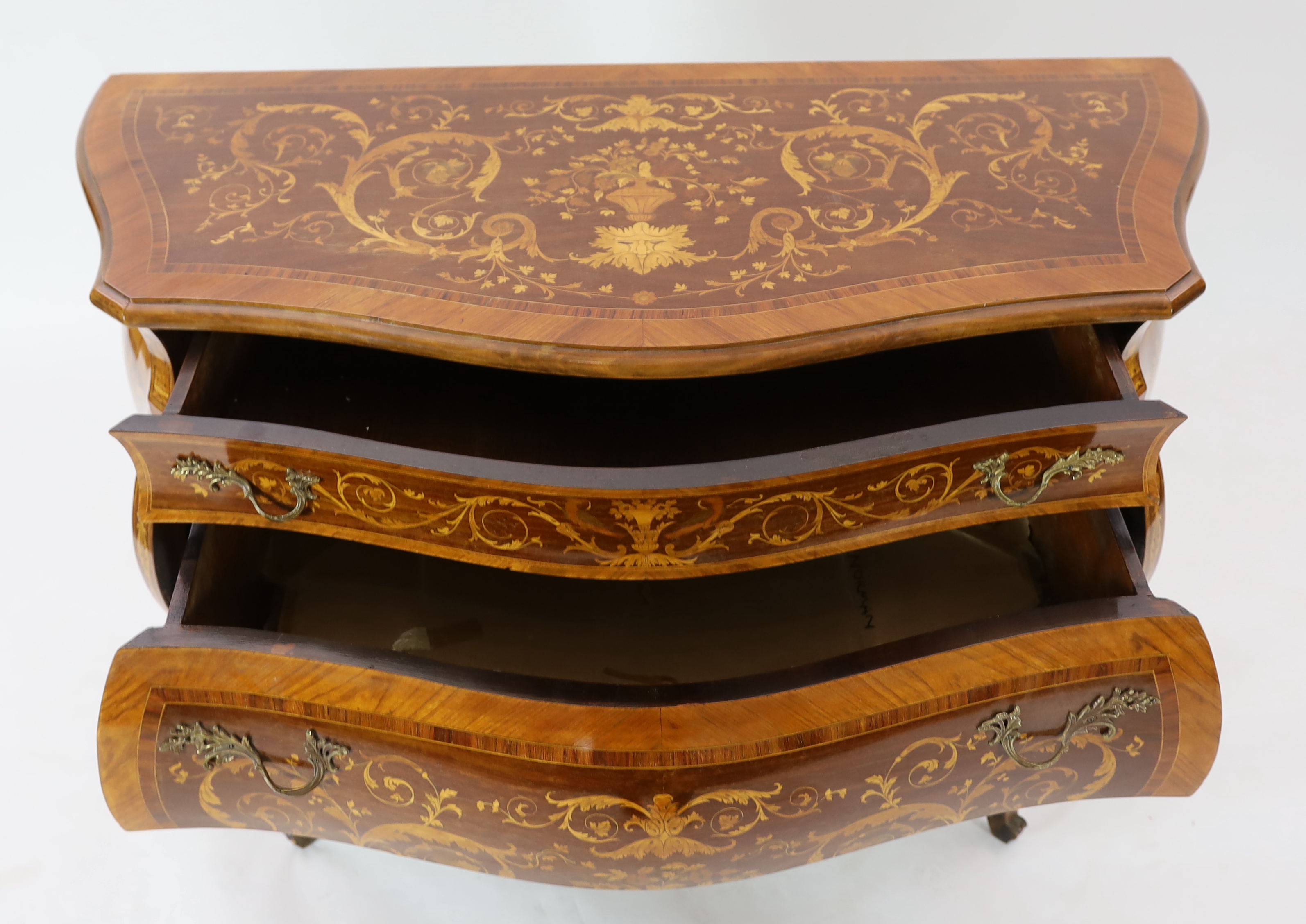 A Continental marquetry inlaid serpentine bombé commode, 130cm wide, 54cm deep, 94cm high